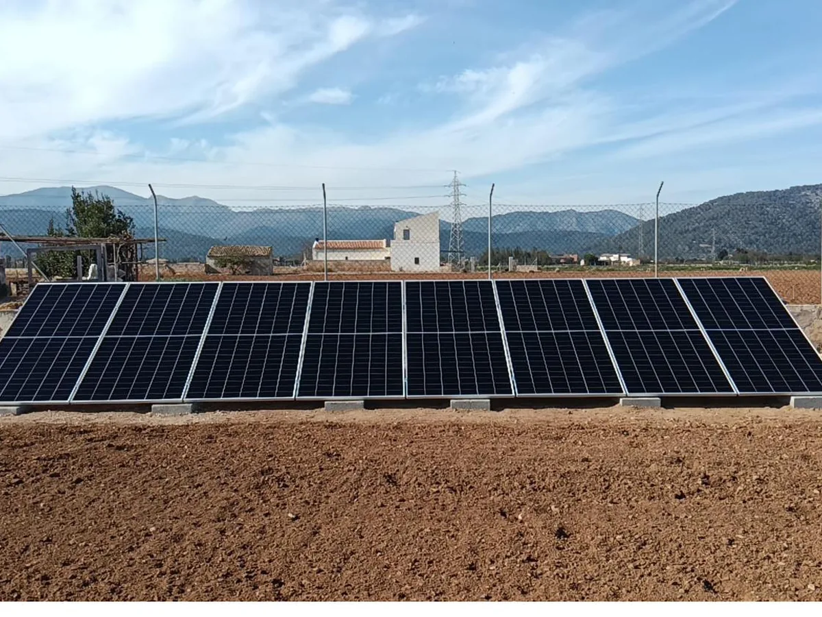 Instalación de paneles solares sobre suelo en finca rústica de Mallorca con casa al fondo